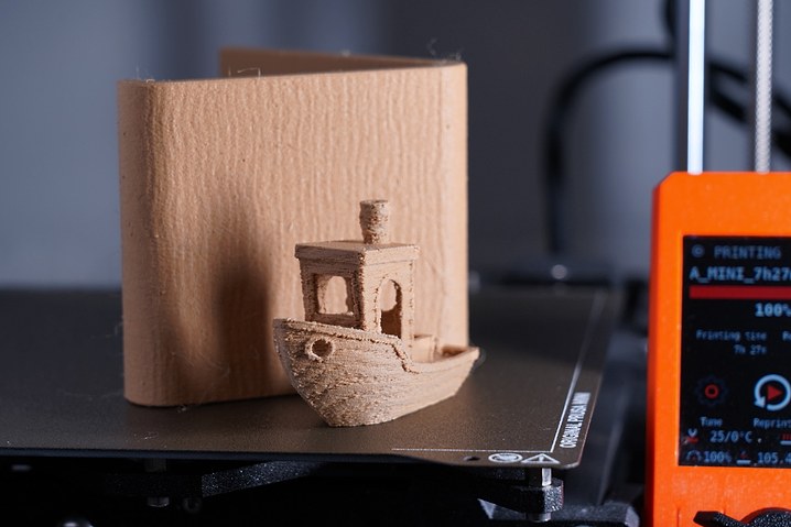 Photo of a phone stand and 3d benchy with a wood texutre